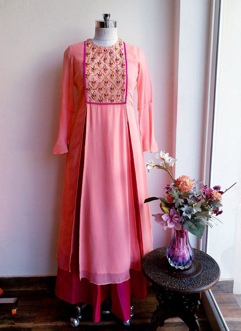 Peach colored faux georgette designer suit with embroidered details and a contrasting tapeta silk ghera