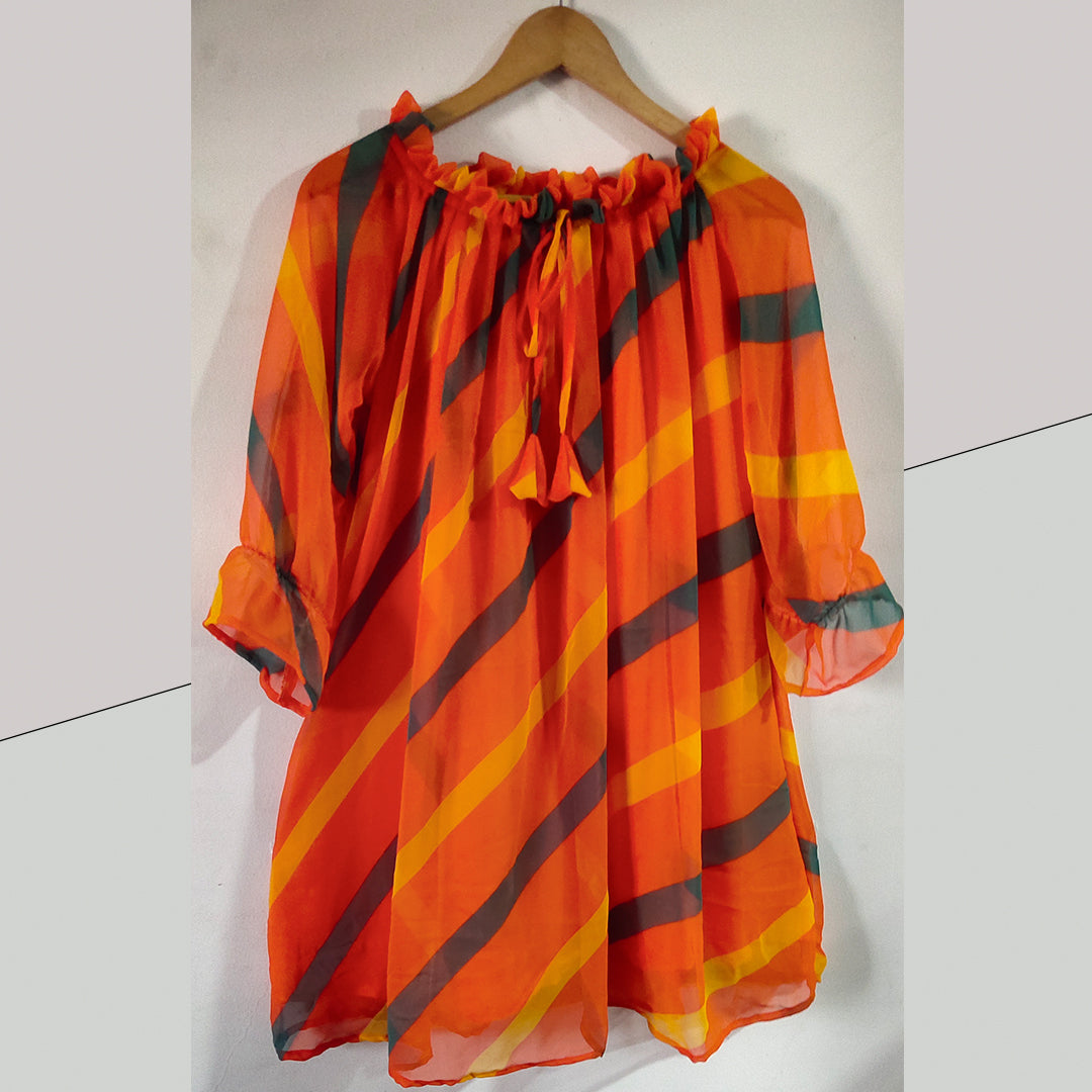 A vibrant orange off-shoulder top featuring a stunning digital flower print and flattering pleats.