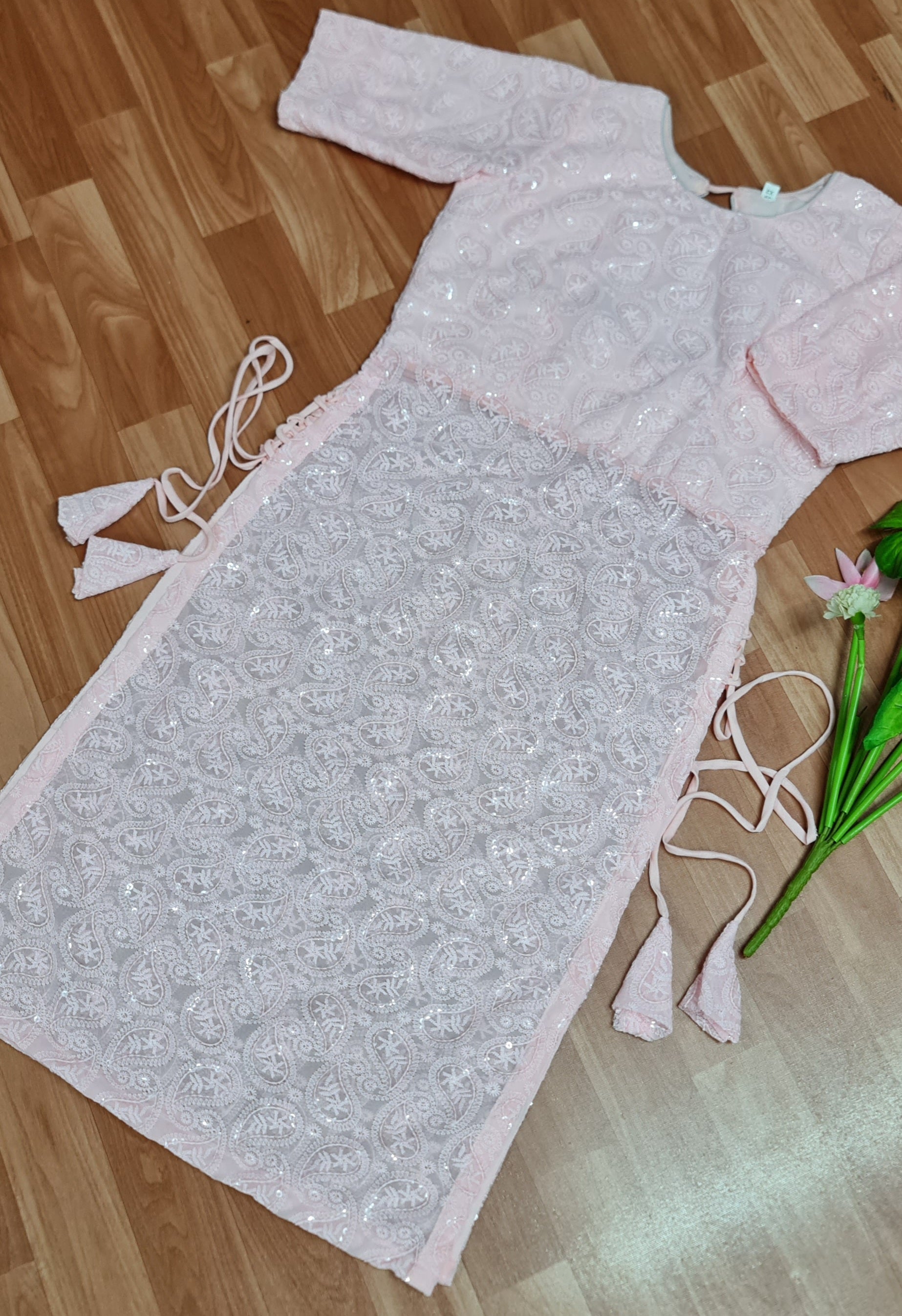 Simple and elegant: A long, flowing peach kurti in soft georgette fabric with delicate side tassels.