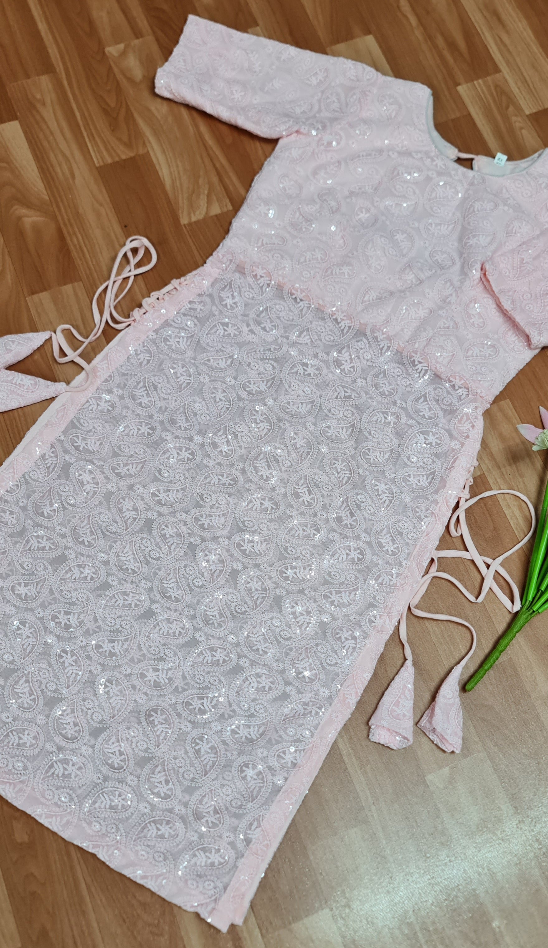 Simple and elegant: A long, flowing peach kurti in soft georgette fabric with delicate side tassels.