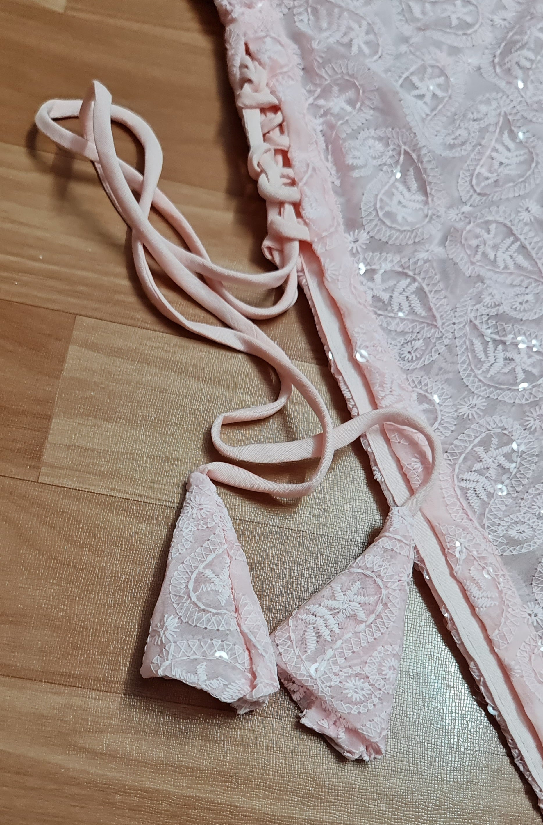 Simple and elegant: A long, flowing peach kurti in soft georgette fabric with delicate side tassels.