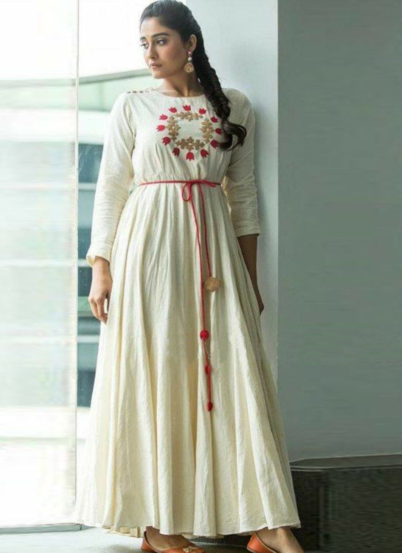 A model dressed in a Prodigious Rayon Off-White Gown adorned with intricate embroidery work, showcasing elegance and sophistication.