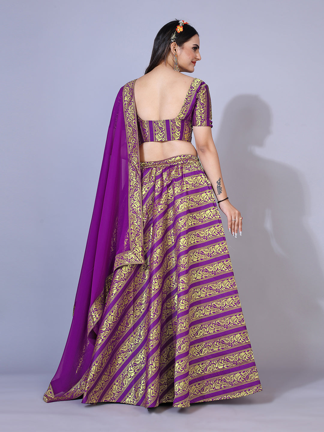 A regal purple lehenga with gold-toned embellishments, paired with a ready-to-wear blouse and matching dupatta. This elegant outfit is perfect for a festive occasion.