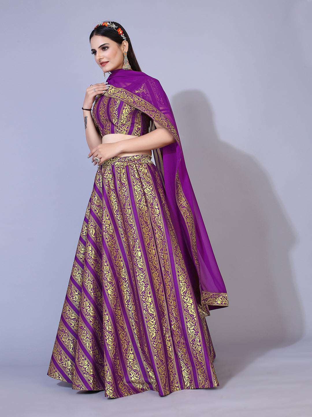 A regal purple lehenga with gold-toned embellishments, paired with a ready-to-wear blouse and matching dupatta. This elegant outfit is perfect for a festive occasion.
