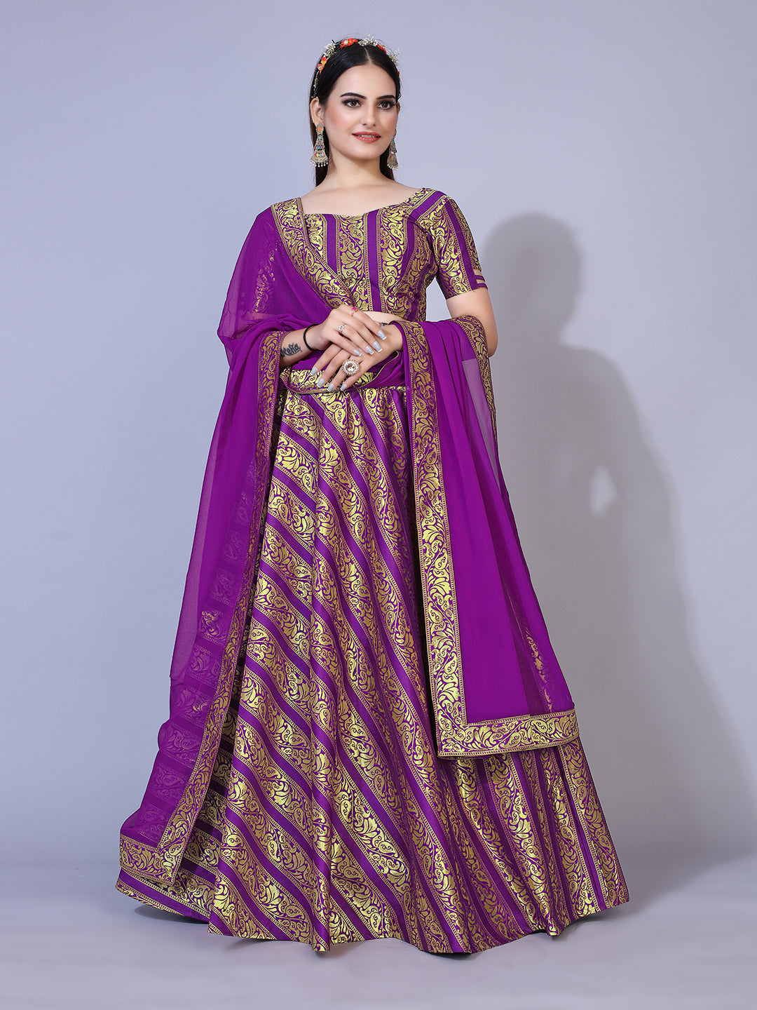 A regal purple lehenga with gold-toned embellishments, paired with a ready-to-wear blouse and matching dupatta. This elegant outfit is perfect for a festive occasion.