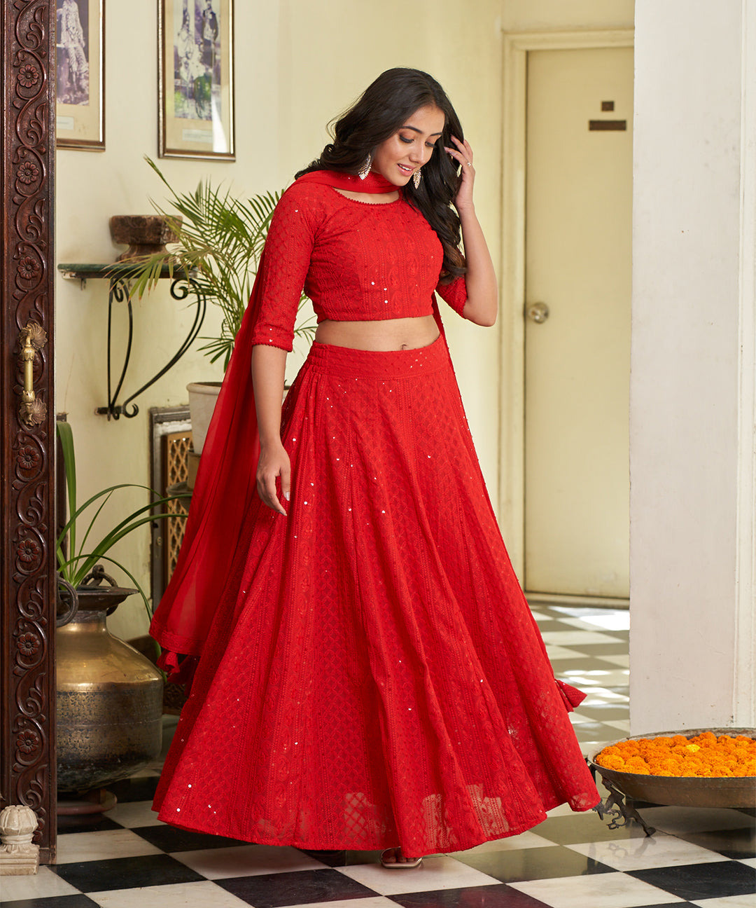 Red A-line lehenga choli with Lucknowi Chikankari work, showcasing intricate embroidery and an elegant design