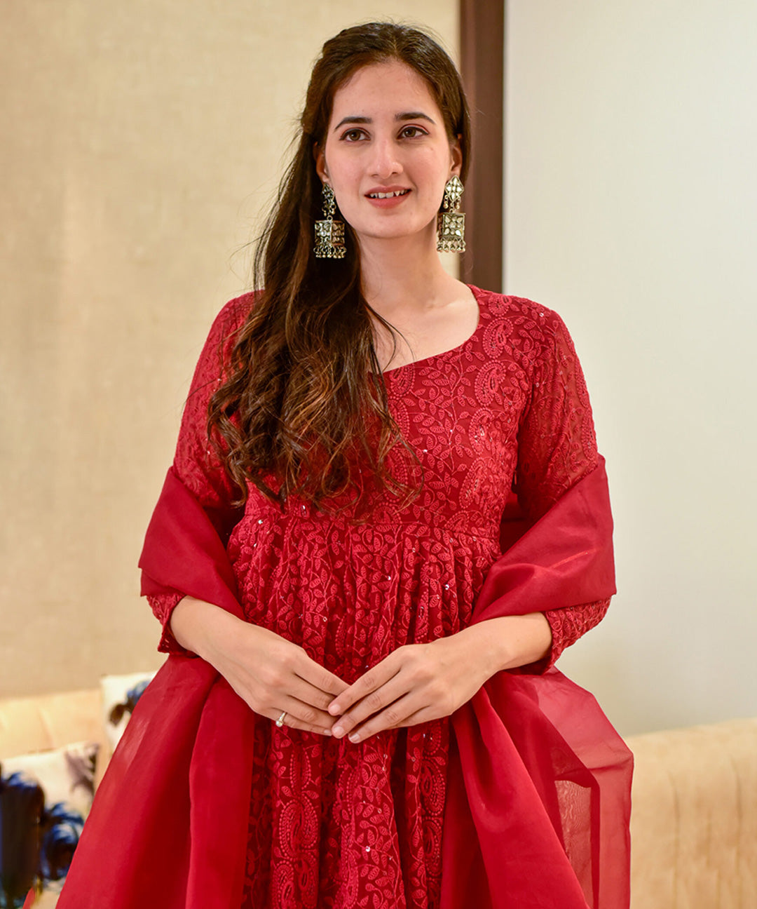 A red georgette Anarkali suit featuring intricate Lucknowi embroidery.