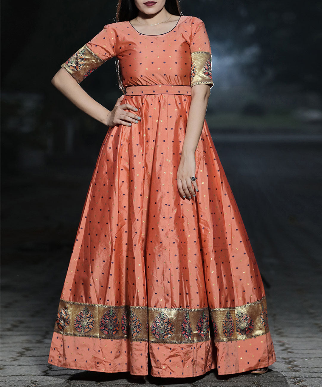Stunning orange-peach colored festive wear gown made of woven Tapetta silk, ideal for special celebrations.