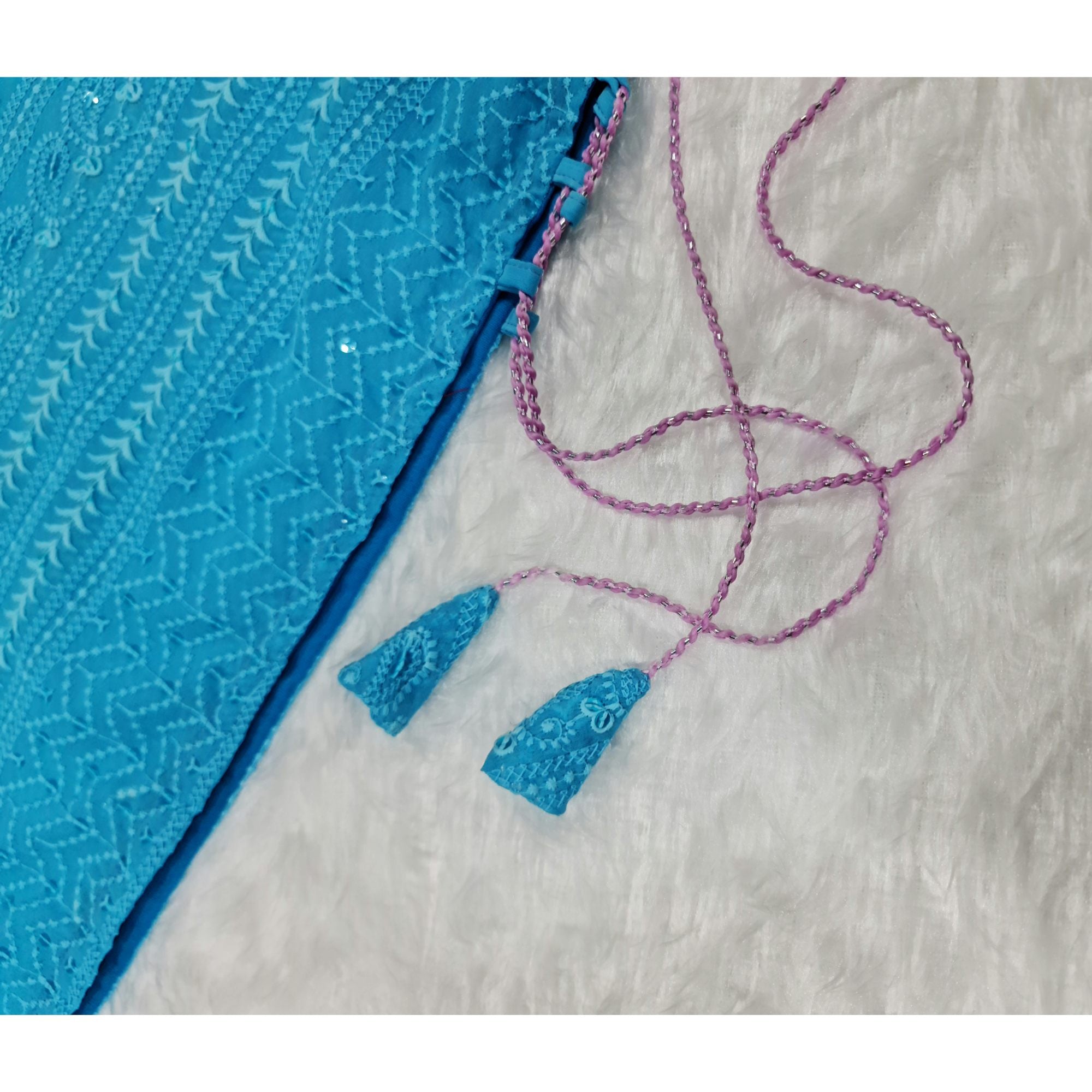 A graceful long kurta in a refreshing turquoise hue, adorned with intricate Chikankari embroidery and stylish side tassels.