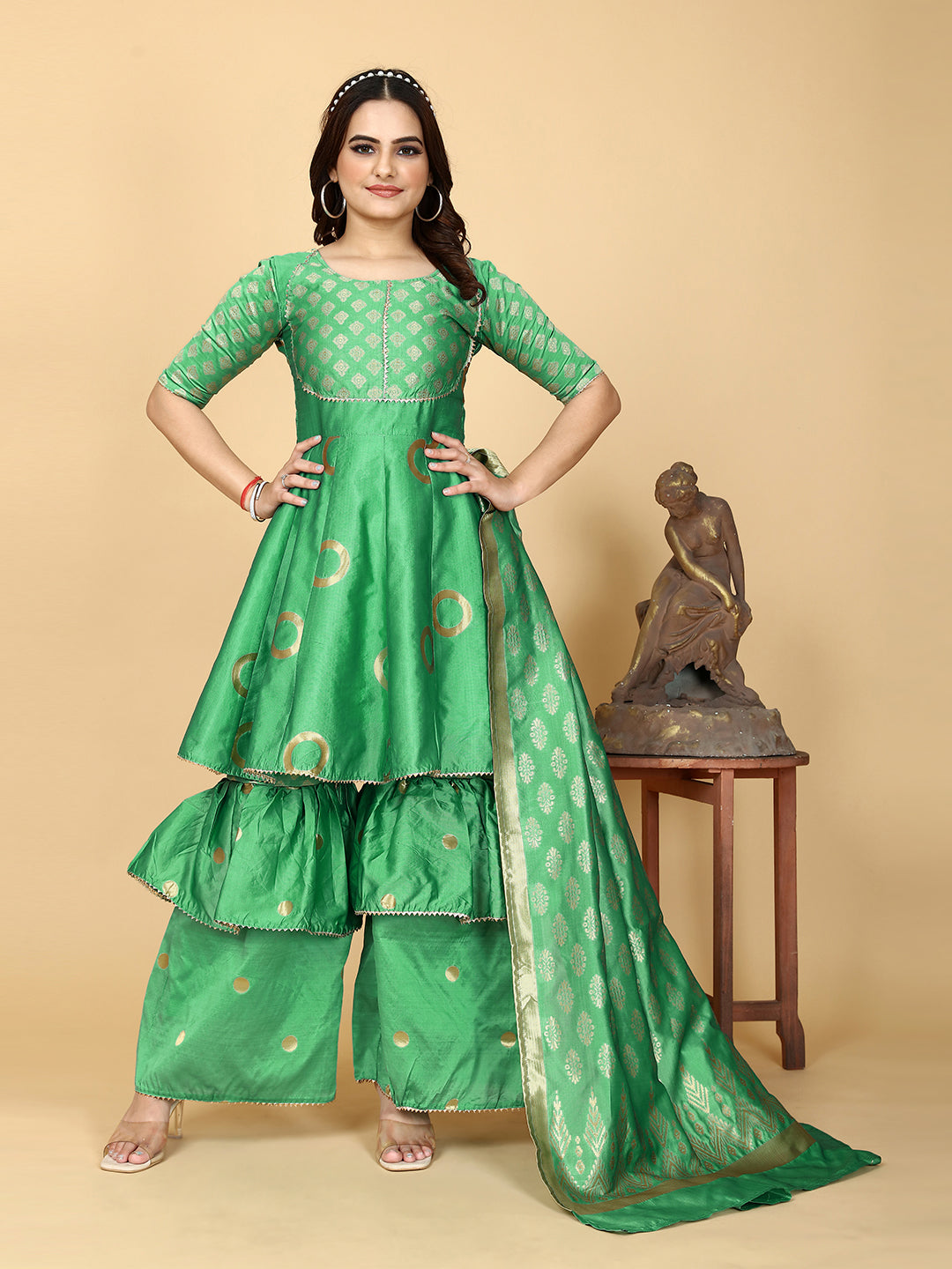 A show-stopping designer sharara set in a mesmerizing shade of magnetic green. Woven for a luxurious feel, this set features a flattering top and wide-leg sharara pants.