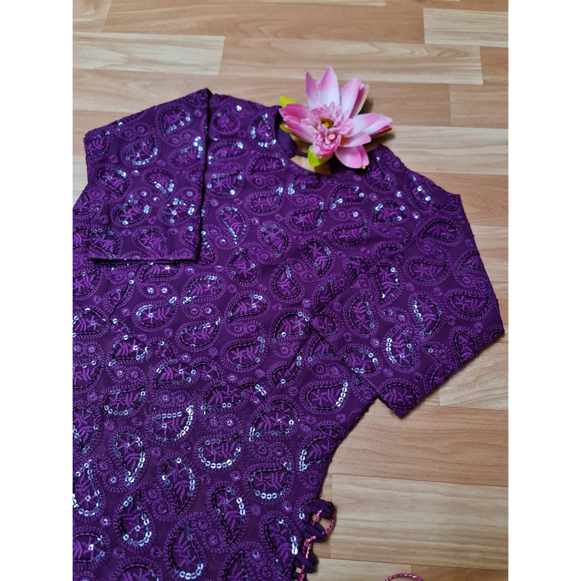 A stunning woman exudes elegance in a flowing purple Chikankari long kurti, adorned with intricate embroidery and delicate side tassels.